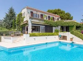 A large pool and terrace with dining area and a traditional 2-storey holiday villa with mature gardens and a large terrace on the first floor.