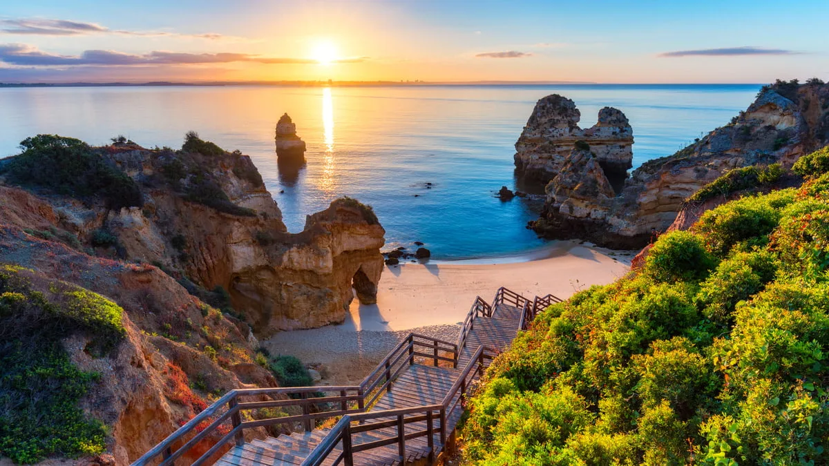 wooden stairs leading down to beautiful isolated beach surrounded by rocky cove
