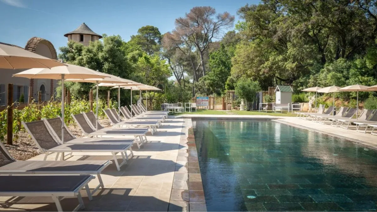 Large shared pool with sunloungers and holiday domaine in the background South of France