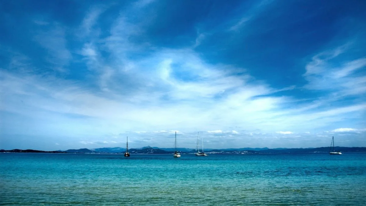 view over the Mediterranean with small sailboats in the foreground