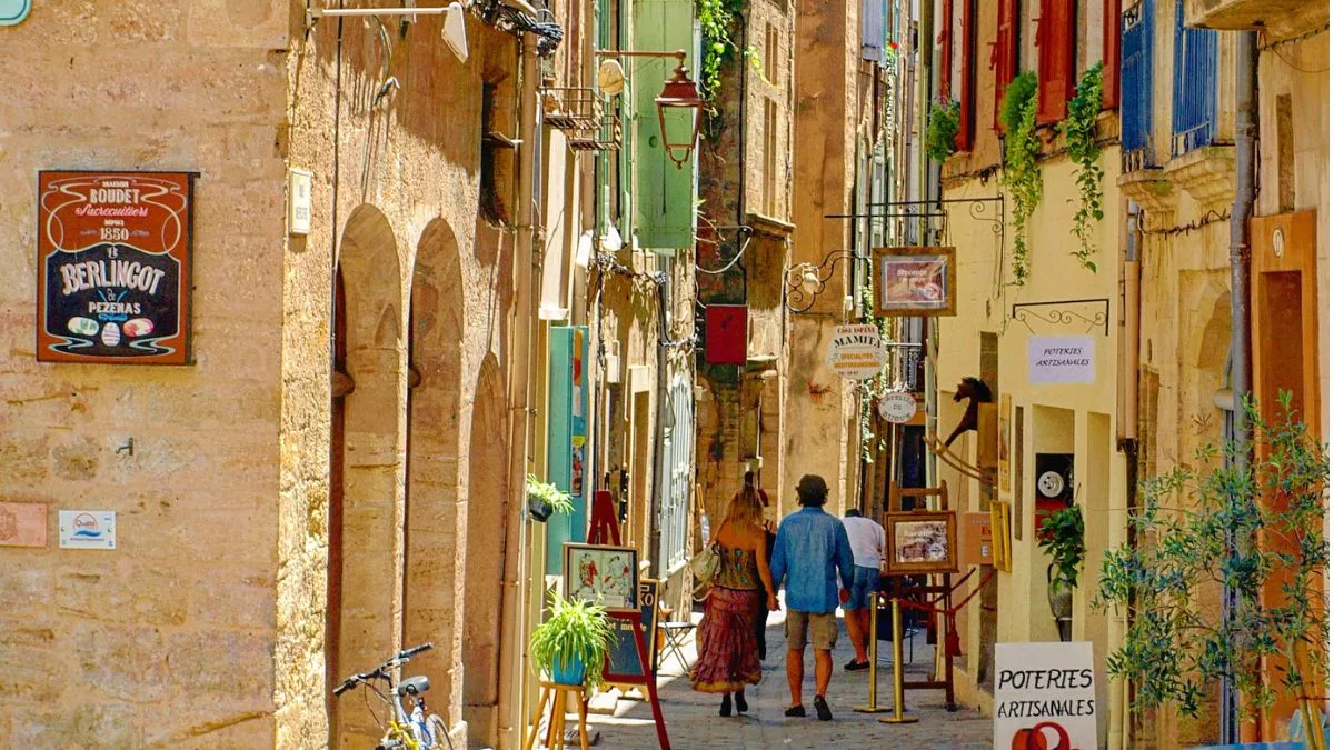 couple wandering down a charming Pezenas street with artist ateliers and boutique shops